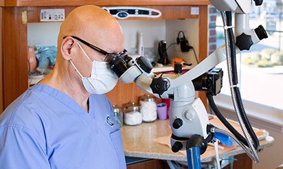 Dental assistant looking through microscope